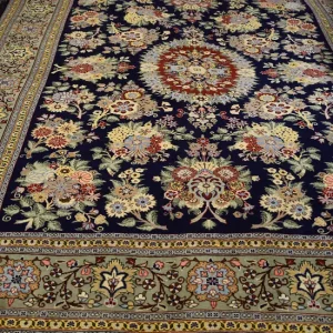 فرش ۳ متری دستباف قم کرک رنگ گیاهی اکازیونی کد ۱۰۳ نمای کلی فرش با زمینه سرمه‌ای، ترنج و حاشیه